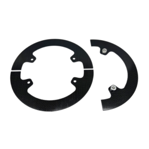 Two black, circular carbon fiber Gear Guards - 4-Spoke Sprocket Hub - 8.5", each featuring textured surfaces, screw holes, and a semicircular cutout, displayed on a white background.