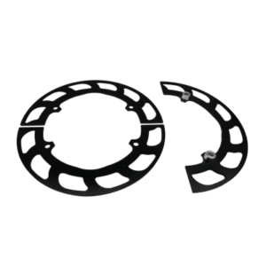 A circular black anodized metal object, broken into two parts, displaying cutout patterns lies against a white background. The larger piece forms most of a full circle, while the smaller one is a segment. This product is known as the Gear Guard - 4-Spoke Sprocket Hub - 8" Black Anodized.