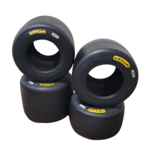 Four Vega racing tires from the "Vega Tire Set - For Pavement - Silver" stacked in a pyramid shape, with yellow Vega branding visible on each tire.